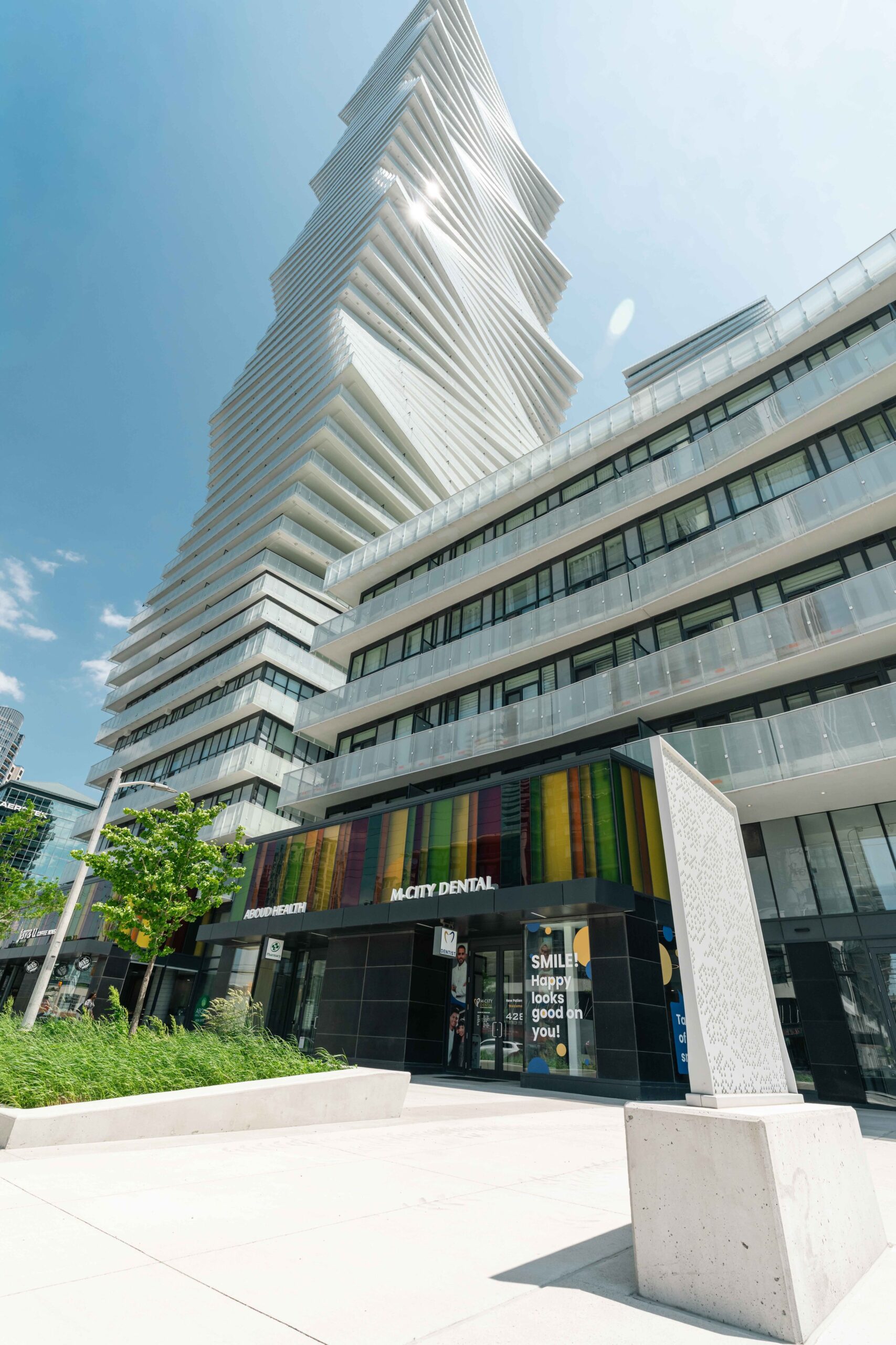 Modern skyscraper with an entrance to M City Dental clinic.